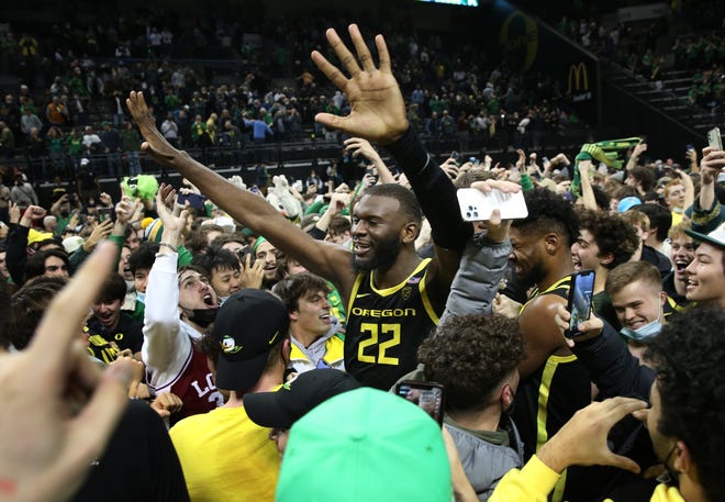 Oregon's Franck Kepnang celebrates with fans as they storm the court after the win over UCLA Feb. 24, 2022.