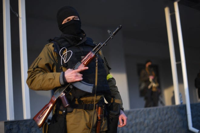 Armed civilian volunteers stand alert on a street in Kyiv on Feb. 25, 2022.