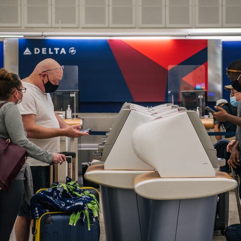 People check in at a Delta station for departing f