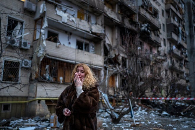 Natali Sevriukova reacts next to her house following a rocket attack in the city of Kyiv, Ukraine, Friday, Feb. 25, 2022.