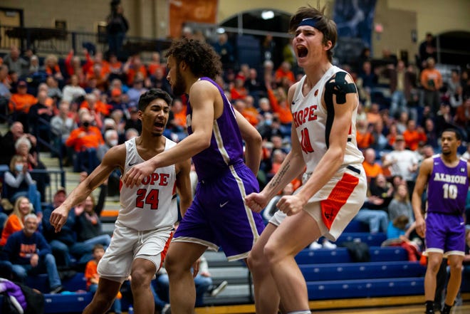 Hope's Eli Schoonveld celebrates a slam dunk to extend Hope's lead over Albion in the conference semi-final game Friday, Feb. 25, 2022, at DeVos Fieldhouse. 