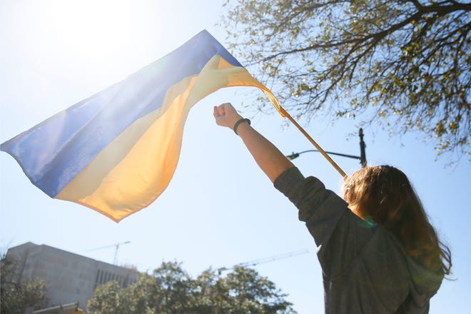 Oksana Teysor waves a Ukrainian flag at a pro-Ukraine protest on 11th St. in front of the Texas State Capitol on Sunday, Feb. 27.