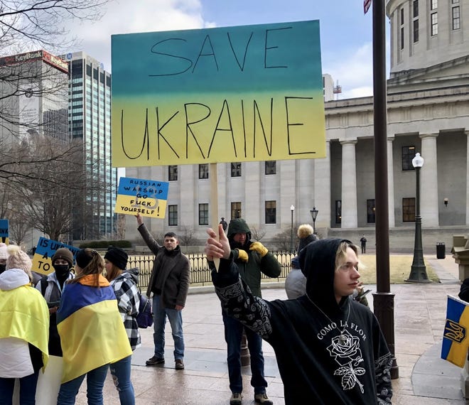 **NOTE USE OF PROFANITY IN SIGN** Paul Hill, who was adopted from Ukraine as a child and lives in central Ohio, was among those gathered at a rally for Ukraine at the Ohio Statehouse on Saturday, Feb. 26, 2022.