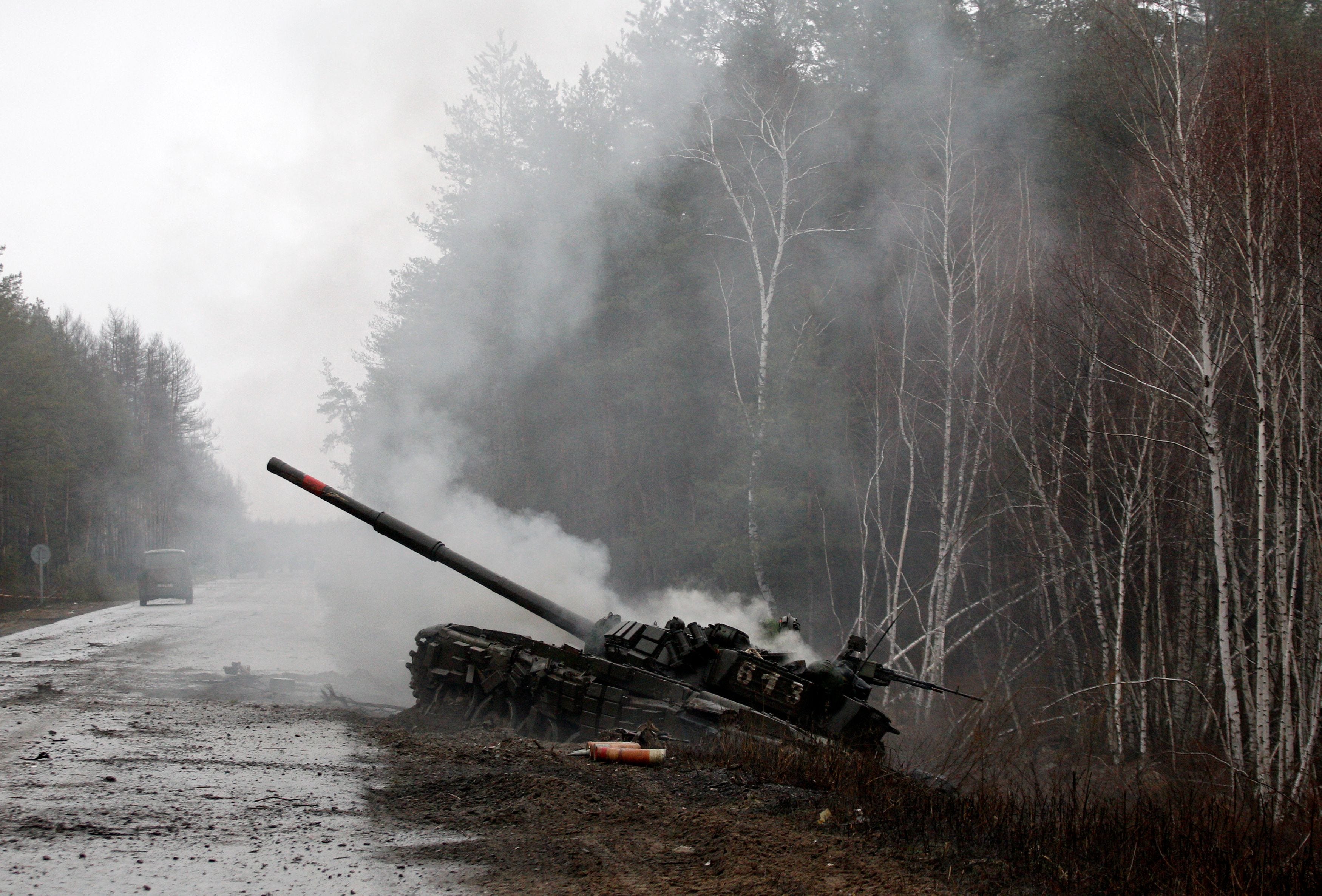 Smoke rises from a Russian tank destroyed by the Ukrainian forces on the side of a road in Luhansk region on Feb. 26, 2022.