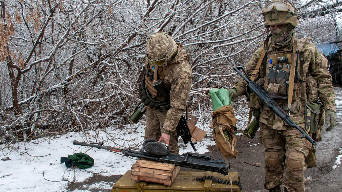 Ukrainian soldiers handle equipment outside Kharkiv, Ukraine, Saturday, Feb. 26, 2022.