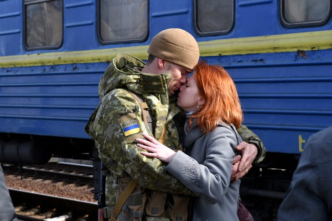 A couple embrace prior to the woman boarding a train leaving for western Ukraine, at the railway station in Kramatorsk, eastern Ukraine, Sunday, Feb. 27, 2022. The U.N. refugee agency says nearly 120,000 people have so far fled Ukraine into neighboring countries in the wake of the Russian invasion. The number was going up fast as Ukrainians grabbed their belongings and rushed to escape from a deadly Russian onslaught.