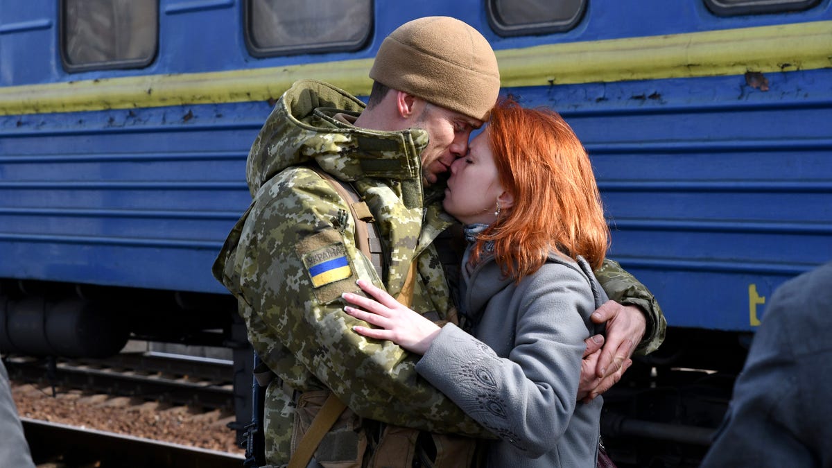 A couple embrace prior to the woman boarding a train leaving for western Ukraine, at the railway station in Kramatorsk, eastern Ukraine, Sunday, Feb. 27, 2022. The U.N. refugee agency says nearly 120,000 people have so far fled Ukraine into neighboring countries in the wake of the Russian invasion. The number was going up fast as Ukrainians grabbed their belongings and rushed to escape from a deadly Russian onslaught.