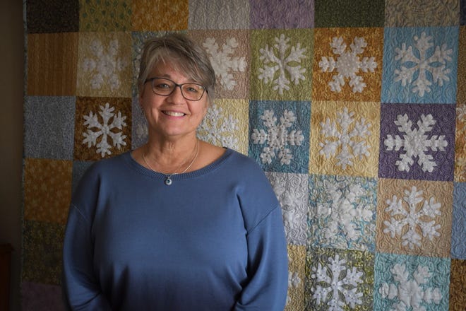 Mary Arndt is an award-winning quilter who will share information on her craft at the March 8 Fremont Area Women’s Connection luncheon. Behind her is her “January Snow” quilt.