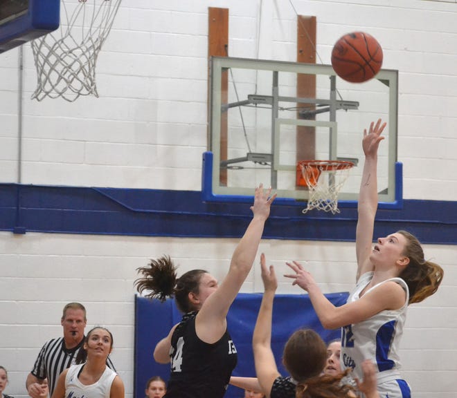 Mackinaw City junior guard Larissa Huffman (right) puts up a shot over a pair of Cedarville-DeTour defenders during the first quarter of a Division 4 girls basketball district semifinal on Monday.