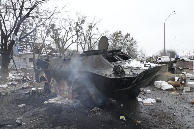 Smoke rises from a damaged armored vehicle at a checkpoint Tuesday in Brovary, outside Kyiv, Ukraine. Russian shelling pounded civilian targets in Ukraine's second-largest city Tuesday and a 40-mile convoy of tanks and other vehicles threatened the capital â€” tactics Ukraine's embattled president said were designed to force him into concessions in Europe's largest ground war in generations.