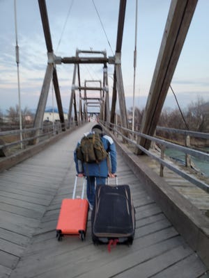 Businessman and educator Reno Domenico of Stratford crosses a wooden bridge alone into Romania in fleeing Ukraine because of the Russian attack on Kyiv, where he worked in recent years.