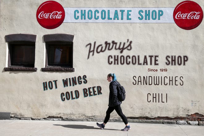 A pedestrian walks past Harry's Chocolate Shop on State Street, Tuesday, March 1, 2022 in West Lafayette.