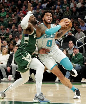 Charlotte Hornets forward Miles Bridges (0) drives past Milwaukee Bucks guard Wesley Matthews (23) during the first half of their game Monday, February 28, 2022 at Fiserv Forum in Milwaukee, Wis. MARK HOFFMAN/MILWAUKEE JOURNAL SENTINEL