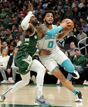 Charlotte Hornets forward Miles Bridges (0) drives past Milwaukee Bucks guard Wesley Matthews (23) during the first half of their game Monday, February 28, 2022 at Fiserv Forum in Milwaukee, Wis. MARK HOFFMAN/MILWAUKEE JOURNAL SENTINEL