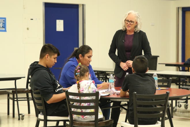 Carlsbad Municipal School's Director Of Curriculum And Instruction Jennifer Timme helps a family access a demo of the new English Language Arts standards through their phones, on Feb. 28, 2022.