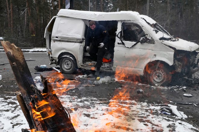A man leaves a vehicle damaged by shelling in Brovary, outside Kyiv, Ukraine, Tuesday, March 1, 2022. Russian shelling pounded civilian targets in Ukraine's second-largest city again Tuesday and a 40-mile convoy of tanks and other vehicles threatened the capital — tactics Ukraine's embattled president said were designed to force him into concessions in Europe's largest ground war in generations.