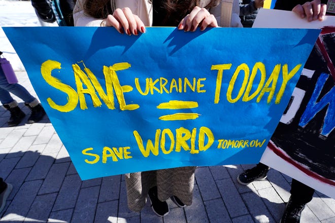 Un manifestant tient une banderole lors d'un rassemblement de soutien à l'Ukraine le 28 février 2022 au Massachusetts Institute of Technology de Cambridge.