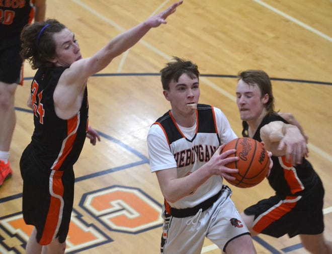 Cheboygan senior guard Carson Mercer (middle) goes up strong while Harbor Springs' Jude Proctor (left) and Trae MacGregor (right) defend during the fourth quarter of a boys basketball matchup in Cheboygan on Tuesday.