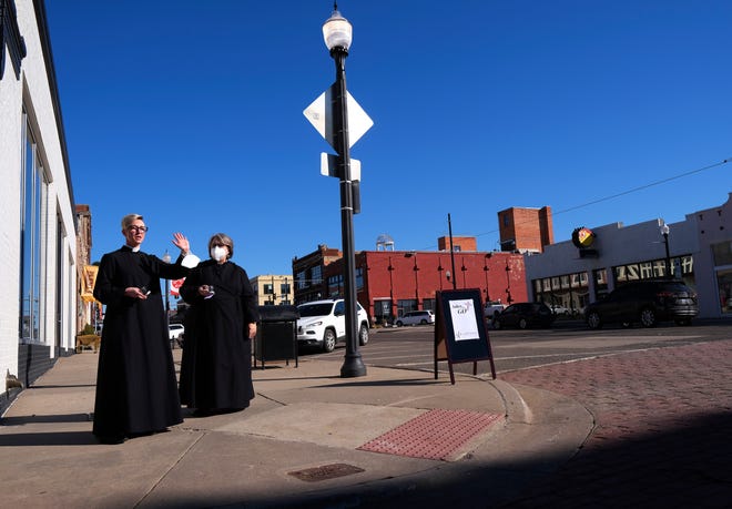 The Rev. Katie Churchwell, dean of St. Paul's Episcopal Cathedral, and one of the church's associate priests, the Rev. Paige Hanks, wave to passers-by as part of the "Ashes to Go" Ash Wednesday outreach on Wednesday at NW 7 and Broadway in Automobile Alley.