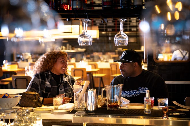 Courtney Buggs, left, dines with her brother Edwin Feagins, right, at Boqueria in Nashville, Tenn., Wednesday, March 2, 2022.