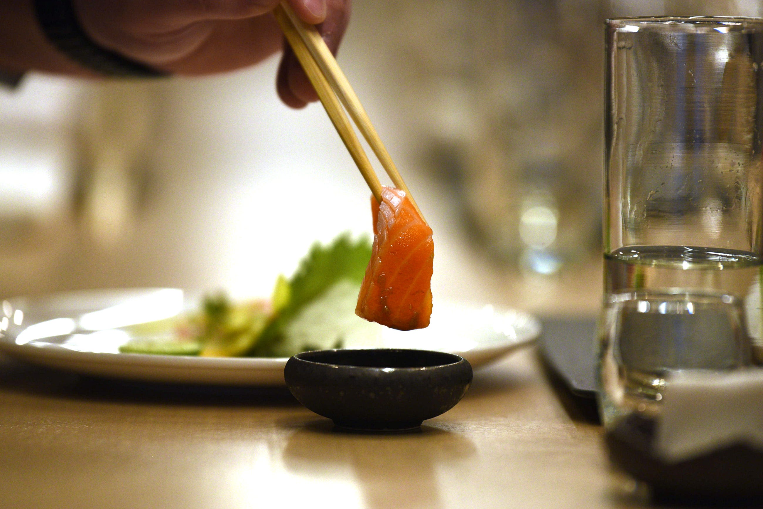 Customers dine on sushi and sashimi, like this piece of sliced salmon at Sushi Kai in Fort Lee.