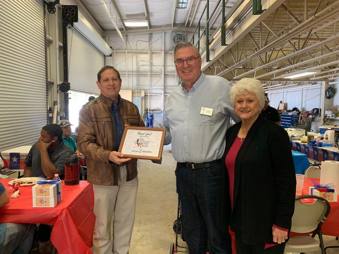 Lakeway Municipal Utility District General Manager Earl Foster, left, presents a token of appreciation to Board President Jerry Hietpas and his wife Rita during the district's 50th anniversary luncheon.