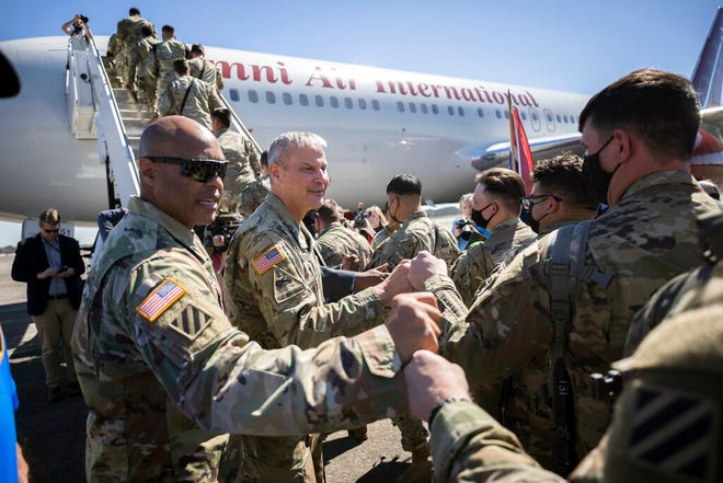 Command Sergeant Major Quentin Fenderson, center, and Major General Charles Costanza fist bump soldiers with the U.S. Army 3rd Infantry Division, 1st Armored Brigade Combat Team as they board an airplane at Hunter Army Airfield during their deployment to Germany, Wednesday March  2, 2022 in Savannah, Ga. The division is sending 3,800 troops as reinforcements for various NATO allies in Eastern Europe. (Stephen B. Morton /Atlanta Journal-Constitution via AP)