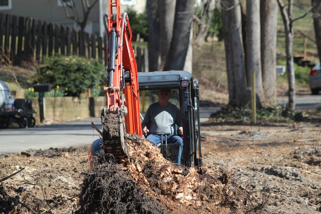 Bill Allan, owner and developer of the lot on North Park Lane, tills the ground to remove tree stumps in preparation for construction.