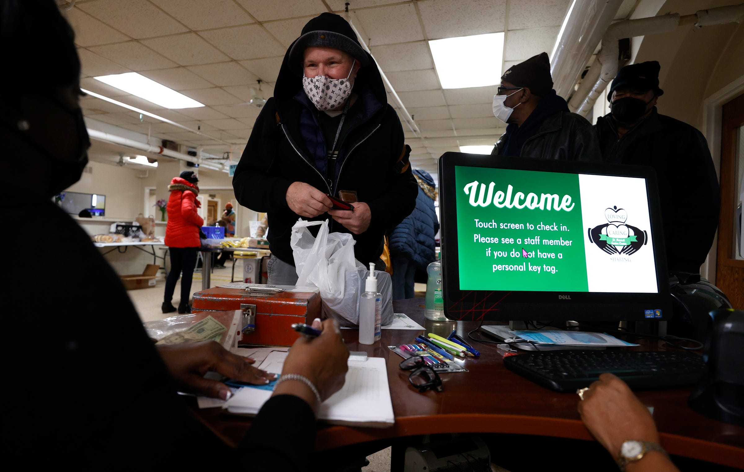 Daniel Spyker, 69 of Detroit talks with staff at the St. Patrick Senior Center in Detroit on Wednesday, March 2, 2022, after presenting his membership card and paying $4 for two complete meals to take home.