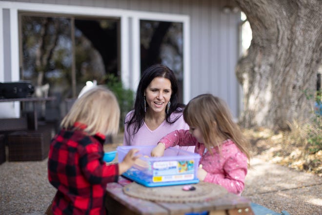 Bianca King, center, plays with her children, Apollo, left, and Indigo in the yard of her Lakeway home. King is suing the city to keep her at-home day care business open.