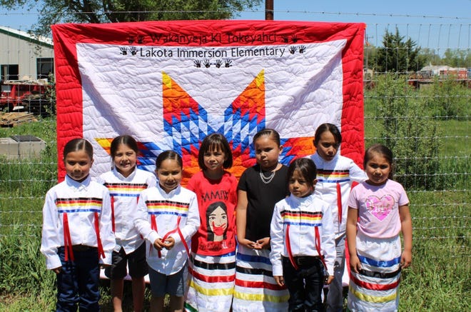 Elementary students celebrate graduation in 2021 at Wakanyeja Tokeyahci, a privately funded Lakota immersion school on the Rosebud Indian Reservation in south-central South Dakota.
