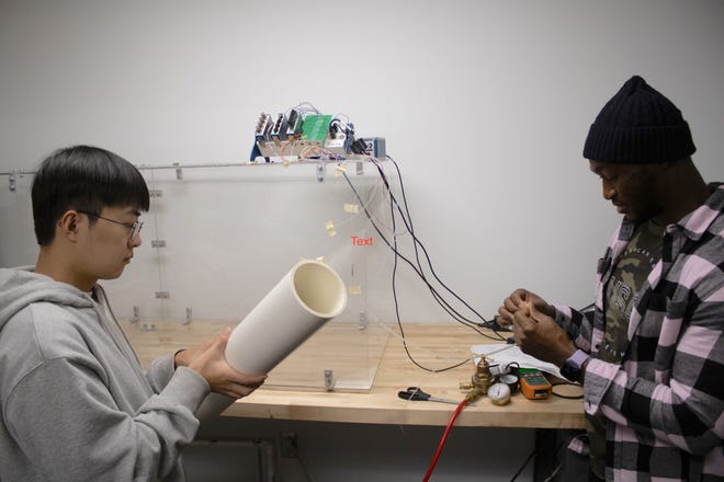 RIDER students Sejin Kim and Fabrice Taondeyande work on equipment to test wind flow.