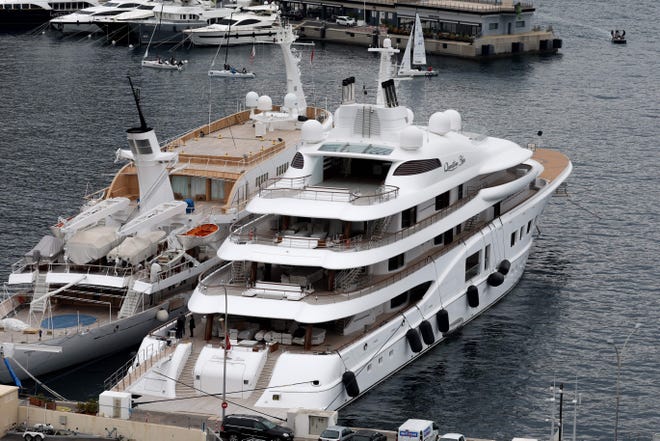 This photograph taken on March 3, 2022 shows the "Quantum Blue" (R), Russian billionaire Sergei Galitsky's yacht, docked in the port of Monaco. - On the same day, a mega-yacht owned by a company linked to the head of Russian oil giant Rosneft has been seized in southern France on March 3, 2022, one of the most tangible acts in the hunt for the luxury assets of Russian oligarchs close to Russian President Vladimir Putin.