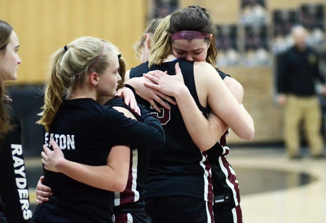 Charlevoix's Taylor Petrosky and Abbey Wright (right), along with other Rayder players, embrace in the seconds after falling to St. Ignace in the Division 3 district championship Friday night.