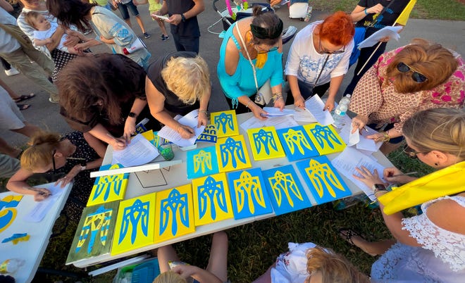 Ukrainians sign letters to President Biden, Senator Rick Scott and Governor Ron DeSantis at a gathering to protest Russia's invasion, Saturday, March 5, 2022 at Spanish River Athletic Park in Boca Raton. 