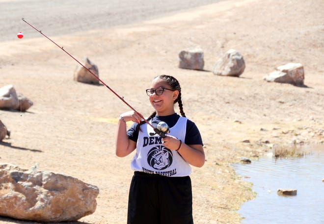 Zenovia Garcia, 10, beams before casting her line into Trees Lake during Saturday's Great Outdoor Adventure in Deming.  Zenovia and her family spent the day fishing for free and enjoying fun outdoor recreation and a "field to table" Having lunch.