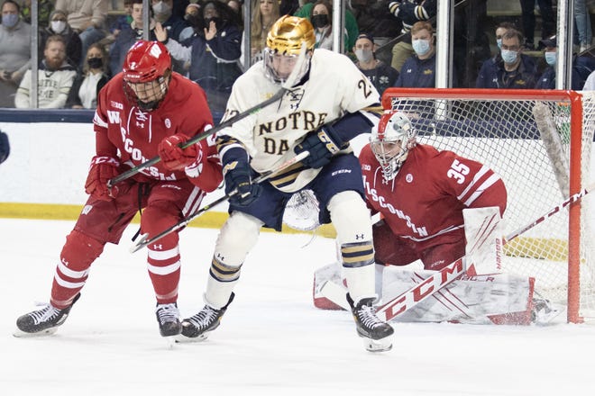 Notre Dame's Jack Adams sets screen in front of Wisconsin's Jared Moe as Wisconsin's Daniel Laatsch defends during the Wisconsin-Notre Dame Big Ten hockey tournament game on Sunday, March 06, 2022, at Compton Family Ice Arena in South Bend, Indiana.