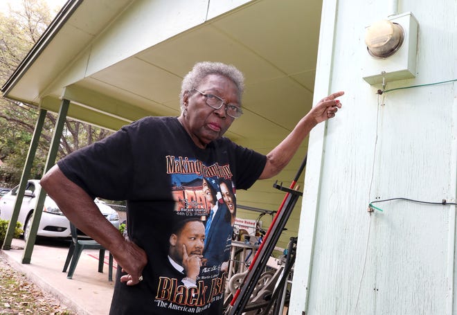 Lillie McGee, who lives alone and says her power bill last month was $400, points to her power meter at her home in Gainesville in 2021. McGee said she is fed up with the high rates that Gainesville Regional Utilities is charging.