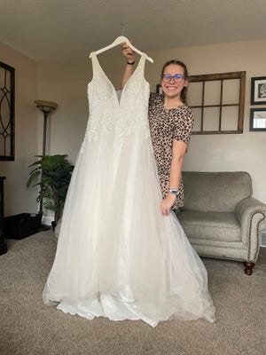 Lindsey Boyer holds her wedding dress that had been lost after the death of the owner of the shop where she purchased the dress.