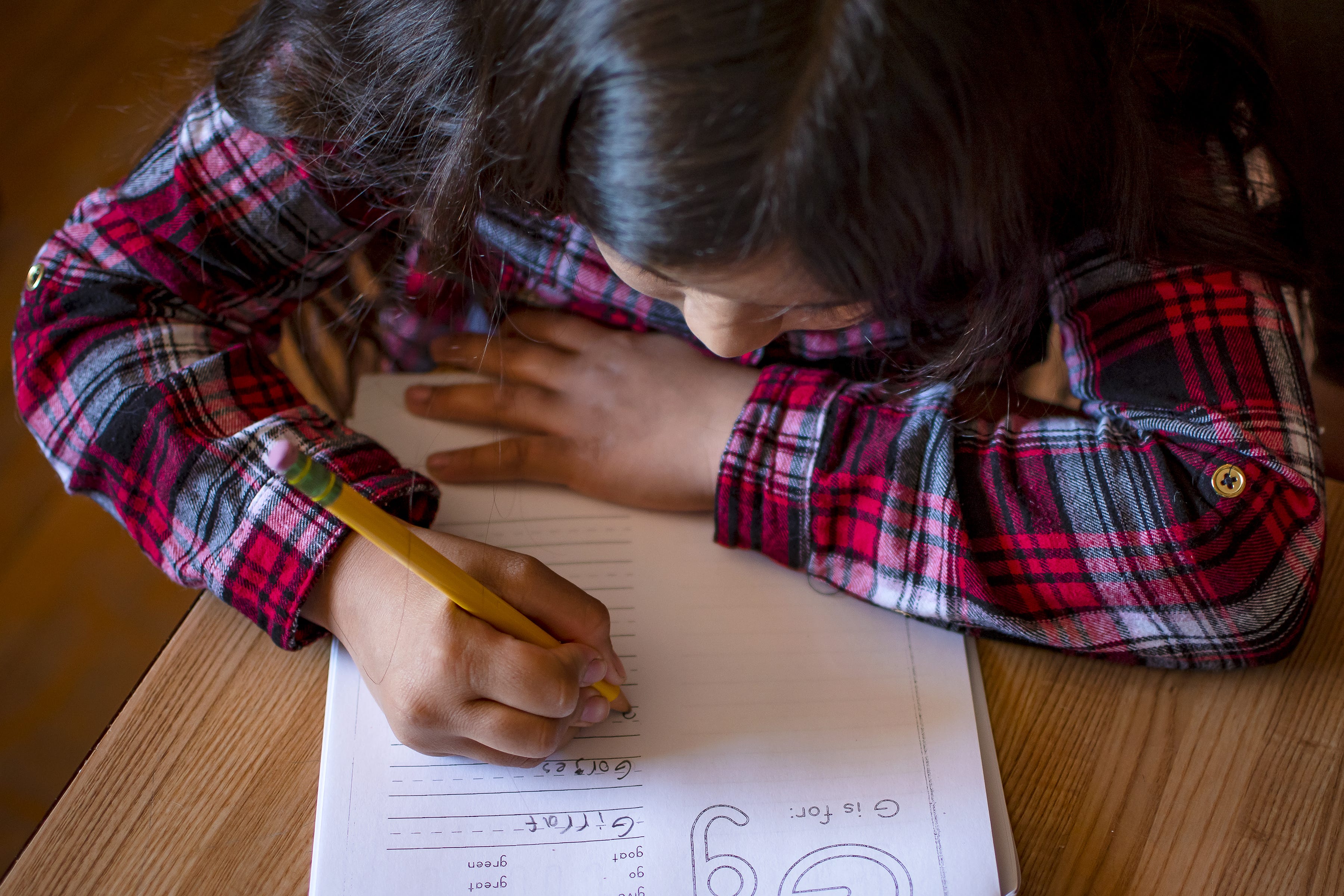 Eight-year-old Fernanda Davila works on a spelling packet at the kitchen table in her Phoenix home on March 8, 2022.
