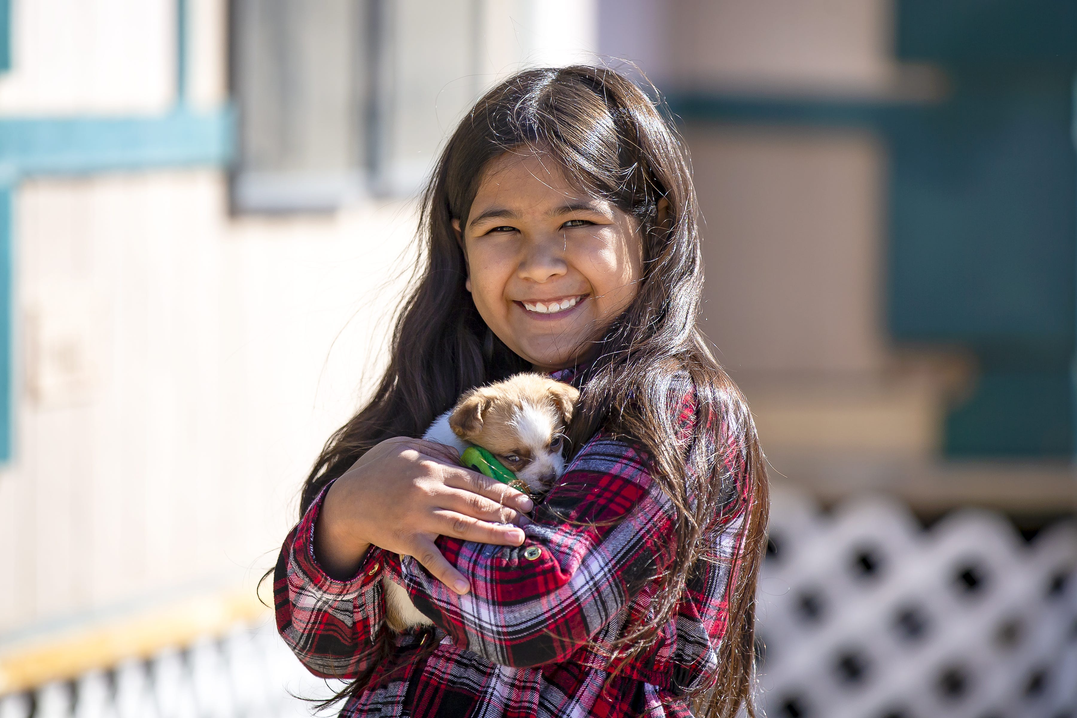 Eight-year-old Fernanda Davila holds her puppy, Dolores, outside her Phoenix home on March 8, 2022.