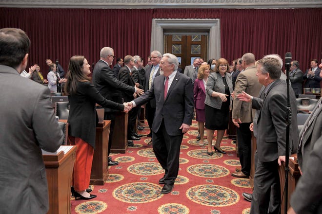 Chief Justice Paul Wilson, center, greets lawmakers on the Missouri House floor prior to his State of the Judiciary address in Jefferson City on March 8, 2022.