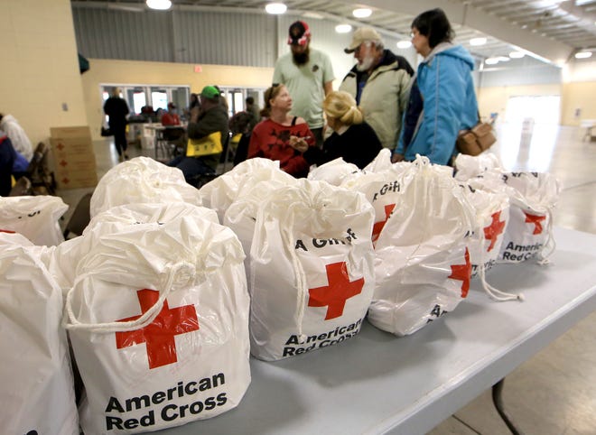 American Red Cross comfort kits line a table as neighbors from Victory Road talk about their losses after the Cottonwood Complex wildfire during the MARC, Multi-Agency Resource Center event, held by Reno County VOAD Tuesday, March 8, 2022, in the Sunflower South Building at the Kansas State Fair.