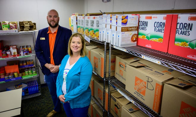 Chris Stone, area director of Community Partnership Schools, and South Woods Elementary School Principal Angela Rodgers stand together in a food pantry on the grounds of the school near Hastings where boxes of food are stored before being delivered to families of students in need on Wednesday, March 9, 2022.