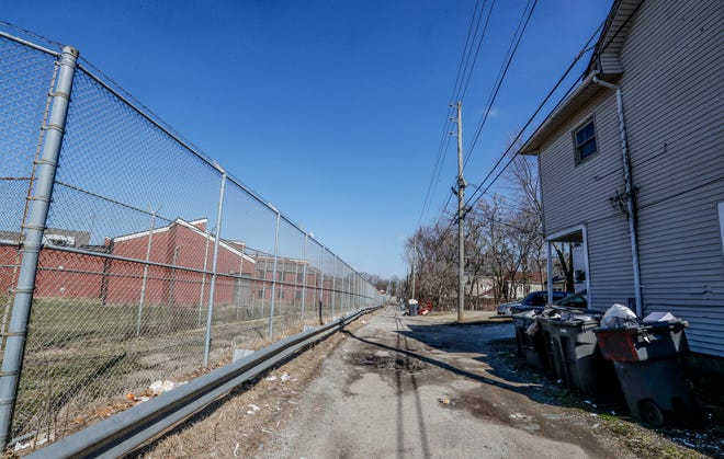 An alley seperates The former Indiana Women's Prison on Randolph St., from the back of homes, Wednesday, March 9, 2022, in Indianapolis. The 15 acre sight surrounded by homes, was the first women's prison in the country, operating for 136 years until it moved to the west side of Indianapolis.