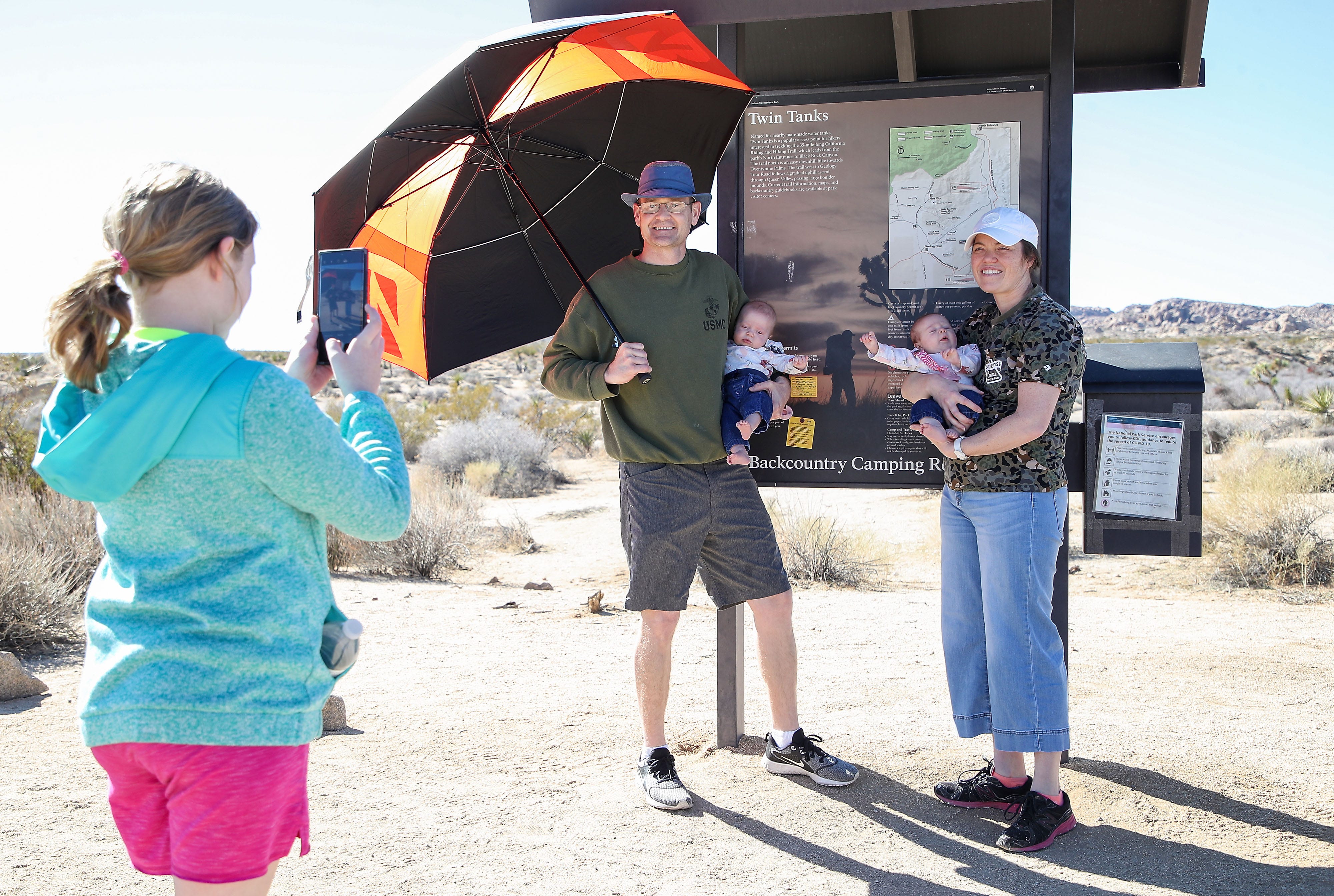 Kayla and Joshua Ottwell have their photo taken Jan. 24, 2022, with their twin daughters Selah and Serah by their daughter Katherine at the Twin Tanks trail marker sign at Joshua Tree National Park. “It’s a positive that people are visiting our parks in record numbers,” he said.