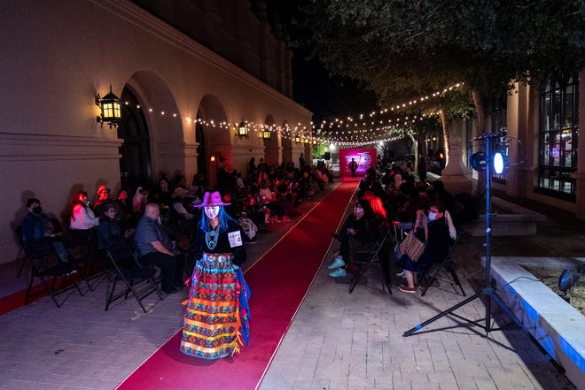 A model wearing a design by Kathleen Tom-Garcia of Kathleen's Design, of the Navajo Nation, walks down the red carpet during the Phoenix Indian Center's Indigenous Community Fashion Showcase at Brophy College Preparatory in Phoenix on March 5, 2022.