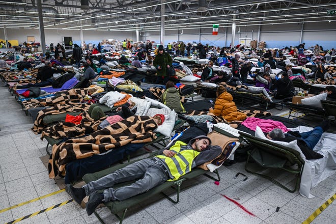 People who fled the war in Ukraine rest inside a temporary refugee shelter that was an abandoned TESCO supermarket after being transported from the Polish Ukrainian border on March 08, 2022 in Przemysl, Poland.