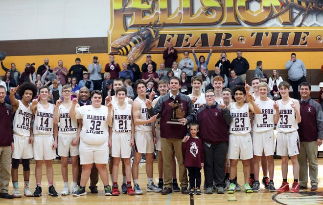 The Harbor Light Christian boys' basketball team celebrates its first district title since 2010 after beating Burt Lake Northern Michigan Christian in Pellston Wednesday night.