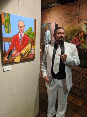 Artist Matthew Brennan IV, who paints under the name Two Thangs, poses with "A Filthy Day in the Neighborhood," a mashup of director John Waters and Mister Rogers, at a show in Boston.